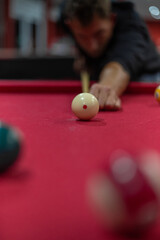 Mann spielt Billard am roten Billardtisch