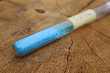 Popular in the chemical industry, a crystalline substance in a test tube is blue copper sulfate....