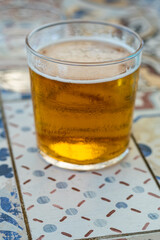 Glass of beer served on a drinking glass on a tiled textured Brick surface