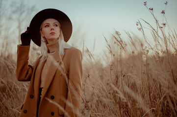 Elegant fashionable blonde woman wearing trendy autumn outfit with classic brown coat, cashmere...