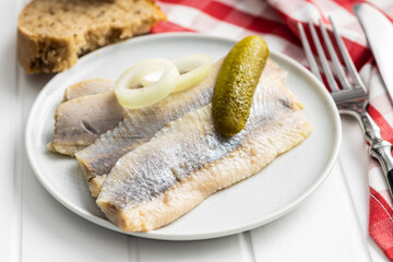 Marinated herring fish on plate.