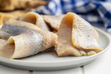 Marinated herring fish on plate.