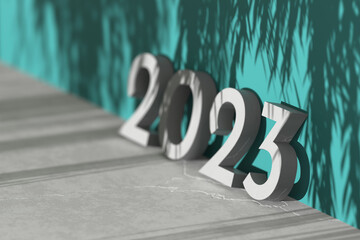 Concrete numbers 2023 leaning against dark teal wall and with shadow of leaves. New year greeting card, 3d render. Minimal geometric scene with copy space. Selective focus
