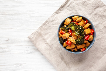 Homemade One-Pan Chicken And Broccoli Stir-Fry in a Bowl on a white wooden background, top view. Flat lay, overhead, from above. Copy space.