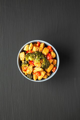 Homemade One-Pan Chicken And Broccoli Stir-Fry in a Bowl on a black background, top view. Flat lay, overhead, from above.