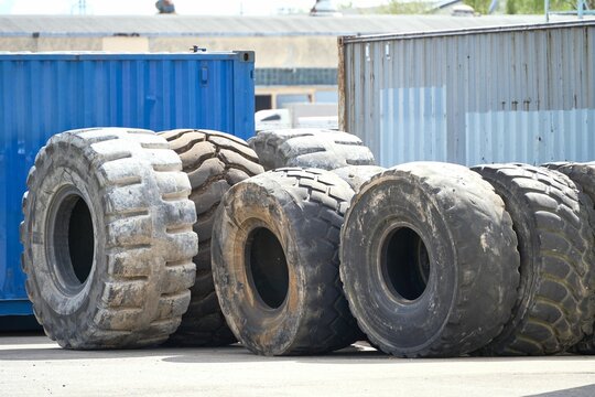 Worn-out resin tires for tractors and machinery in front of containers
