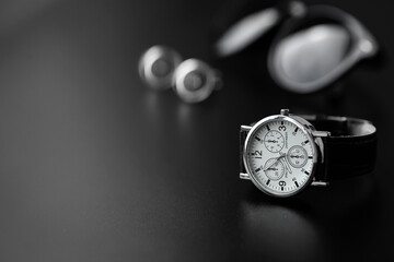 Naklejka na ściany i meble Business accessories. Mens watch and cufflinks isolated on black background.
