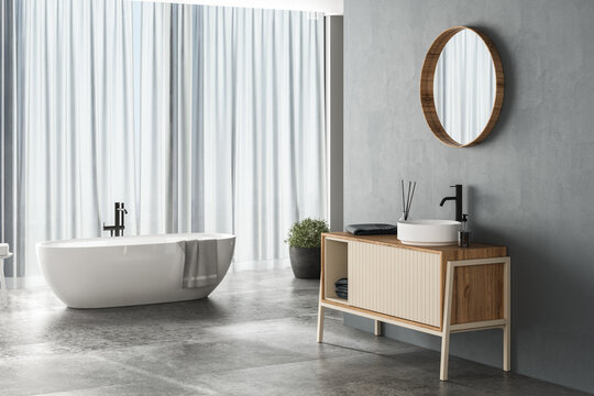 Modern bathroom interior with blue background, concrete flooring, white bathtub, shower and sink, side view. Minimalist bathroom with modern furniture. 3D rendering