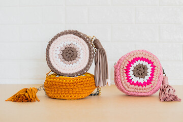 Woman trendy crochet purse on beige background. Fashion concept