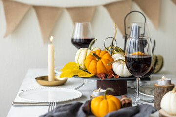 Fototapeta na wymiar Idea for a beautiful autumn setting for thanksgiving family dinner or wedding. Orange pumpkin as decor. Cozy fall home atmosphere.