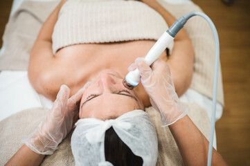 Obraz na płótnie Canvas Beauty professional giving facial treatment to a female client