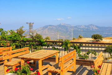 Wooden tables on the terrace of a restaurant in the mountains with a beautiful view. Southern coastal Taurus, Turkey