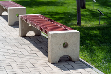 Stone concrete minimalist benches with wooden logs, outdoor seating in public place. Long benches with wooden seat for pedestrians to relax at city park. - Powered by Adobe