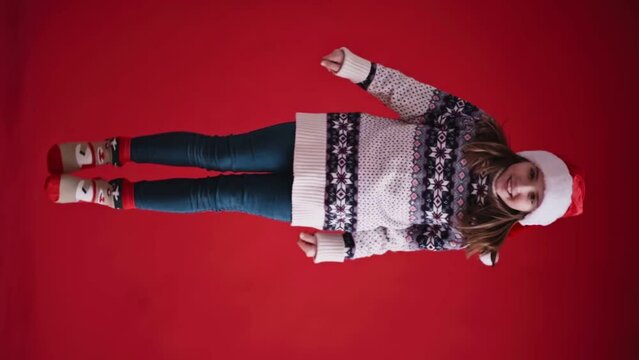 Happy girl jumps on red background. Vertical orientation video. 