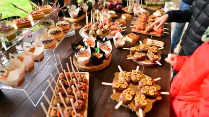 A close-up of carefully selected delicious  cookies filled with chocolate ganache, caramel and nuts in an artistic composition. Gourmet cupcakes decorated .