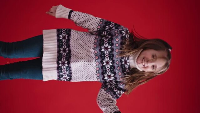 Happy girl jumps on red background. Vertical orientation video. 