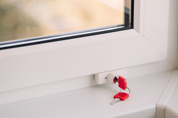 Close-up of child safety lock on a window frame an apartment on a high floor. Security lock for windows ensures the safety of your children and prevents accidents