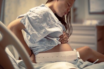 A woman having painful contractions before birth, waiting in the hospital delivery room. Women in...
