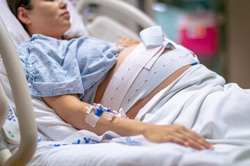 A woman in labor, giving birth in the hospital. Childbirth and pregnancy. - obrazy, fototapety, plakaty
