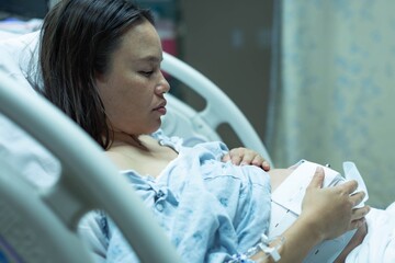 A sad pregnant woman in the hospital suffering from prenatal depression and regret. Abortion.
