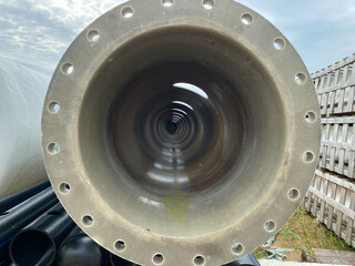 Large diameter plastic polypropylene pipe with flange in open air storage warehouse for storage of materials and industrial equipment