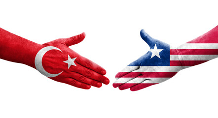 Obraz premium Handshake between Liberia and Turkey flags painted on hands, isolated transparent image.