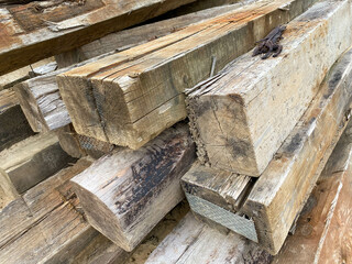 Large wooden rectangular logs or large diameter square cross ties at a construction site