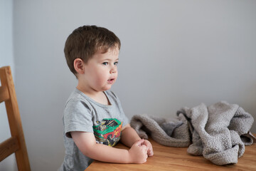 Little boy is fooling around at the kitchen table