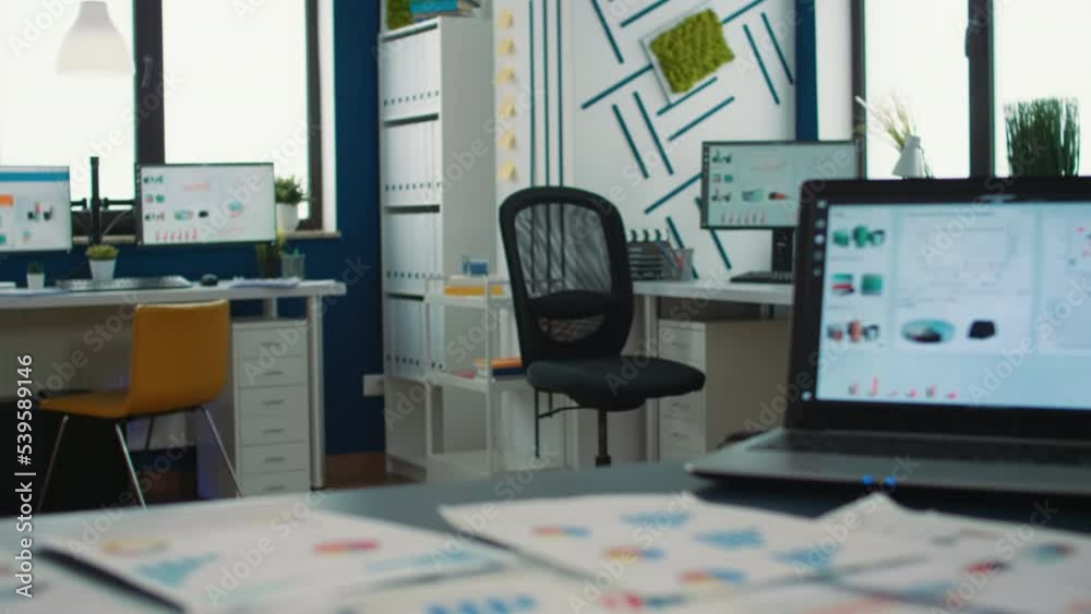 Poster empty startup office with multiple computer screens displaying financial statistics and closeup on l