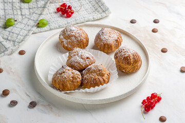 profiteroles on white plate on marble table