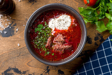 Borscht with sour cream top view on wooden table