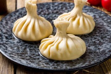 Khinkali with cheese suluguni on plate on wooden table macro close up