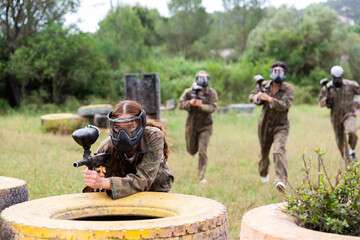Fototapeta premium Team of friends paintball players playing together in battle in forest