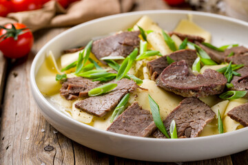 Beshbarmak from beef, Uzbek kitchen on old wooden table, macro close up
