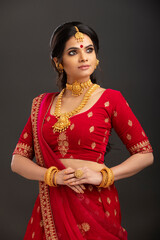 Pretty Indian young Hindu Bride against grey background.