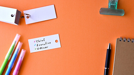 There is word card with the word Chief Executive Officer on the desk.