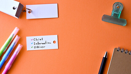 There is word card with the word chief information officer on the desk.