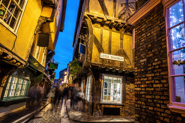 A Chirstmas night view of Shambles, a historic street in York featuring preserved medieval...