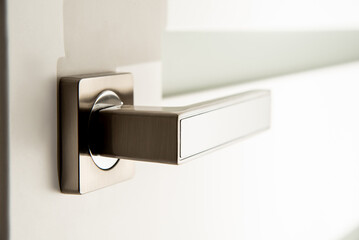 Obraz premium modern metal door handle on white door