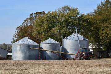 Tractor by Grain Bins in a Farm Field
