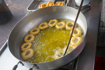 Picarones are ring-shaped fried sweets made with wheat flour dough mixed with pumpkin, and...