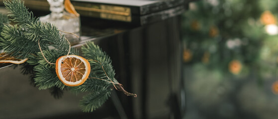 Rustic decorated ornament on Christmas tree with dried orange slices, sustainable Christmas decors concept
