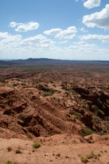 Fototapeta na wymiar The steep canyon. Panorama view of the red desert, cliffs, orange sandstone formations and rocky mountains in the horizon in Sierra de las Quijadas national park in San Luis, Argentina.