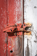 Rusty barn hinge on red and white barn background
