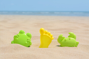 Fototapeta na wymiar Set of colorful beach toys on sand near sea, space for text