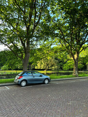 Modern car parked near lake on sunny day