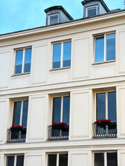 Fototapeta na wymiar Modern building exterior with flowers on window railings