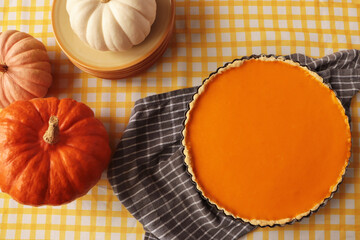 Delicious homemade pie and pumpkins on table, flat lay