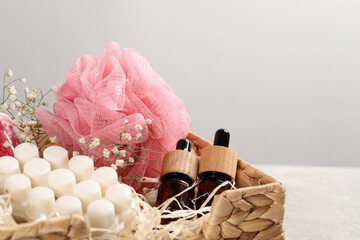 Spa gift set of different luxury products in wicker basket on table, closeup. Space for text