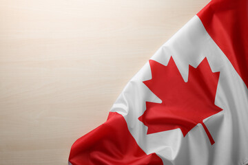 Flag of Canada on wooden table, top view. Space for text